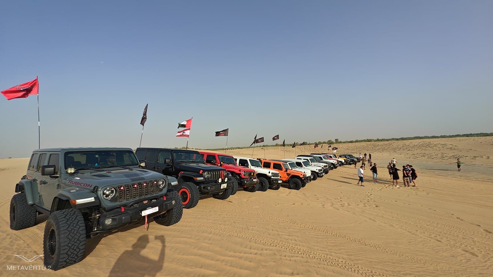 A long line of Jeeps drawn up on the sand
