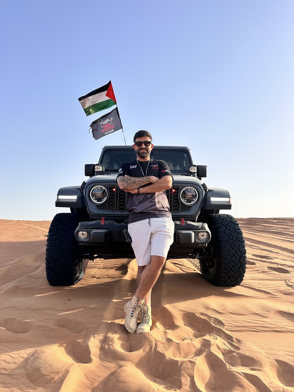 A Jeep on a dune flying the UAE flag